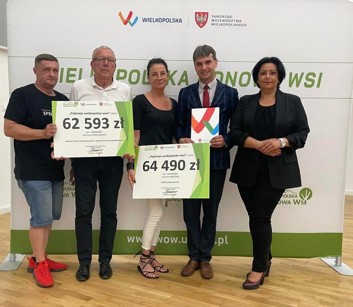 Zdjęcie przedstawia osoby trzymające granty na nowe projekty