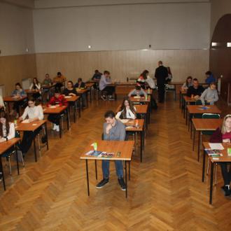 Zdjęcie przedstawia grupę osób, rozwiązujących test.